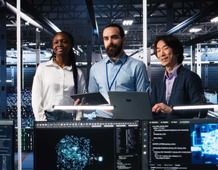 Happy data center colleagues collaborating on neural network software development. Cheerful teamworking server hub coworkers implementing machine learning technology in workplace, camera A